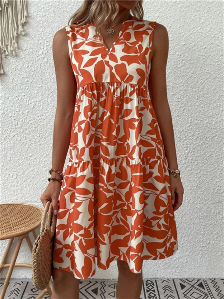 Tiered A-line women's summer mini dress, featuring a chic leaf print and V-neck for vacation.