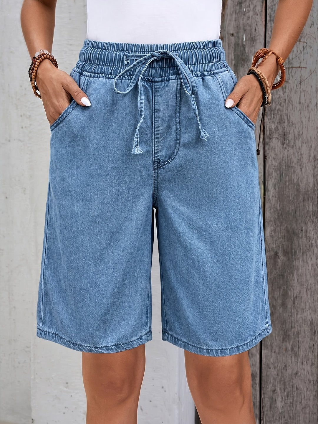 Women's light blue denim Bermuda shorts with comfortable drawstring elastic waist, perfect for casual summer wear.