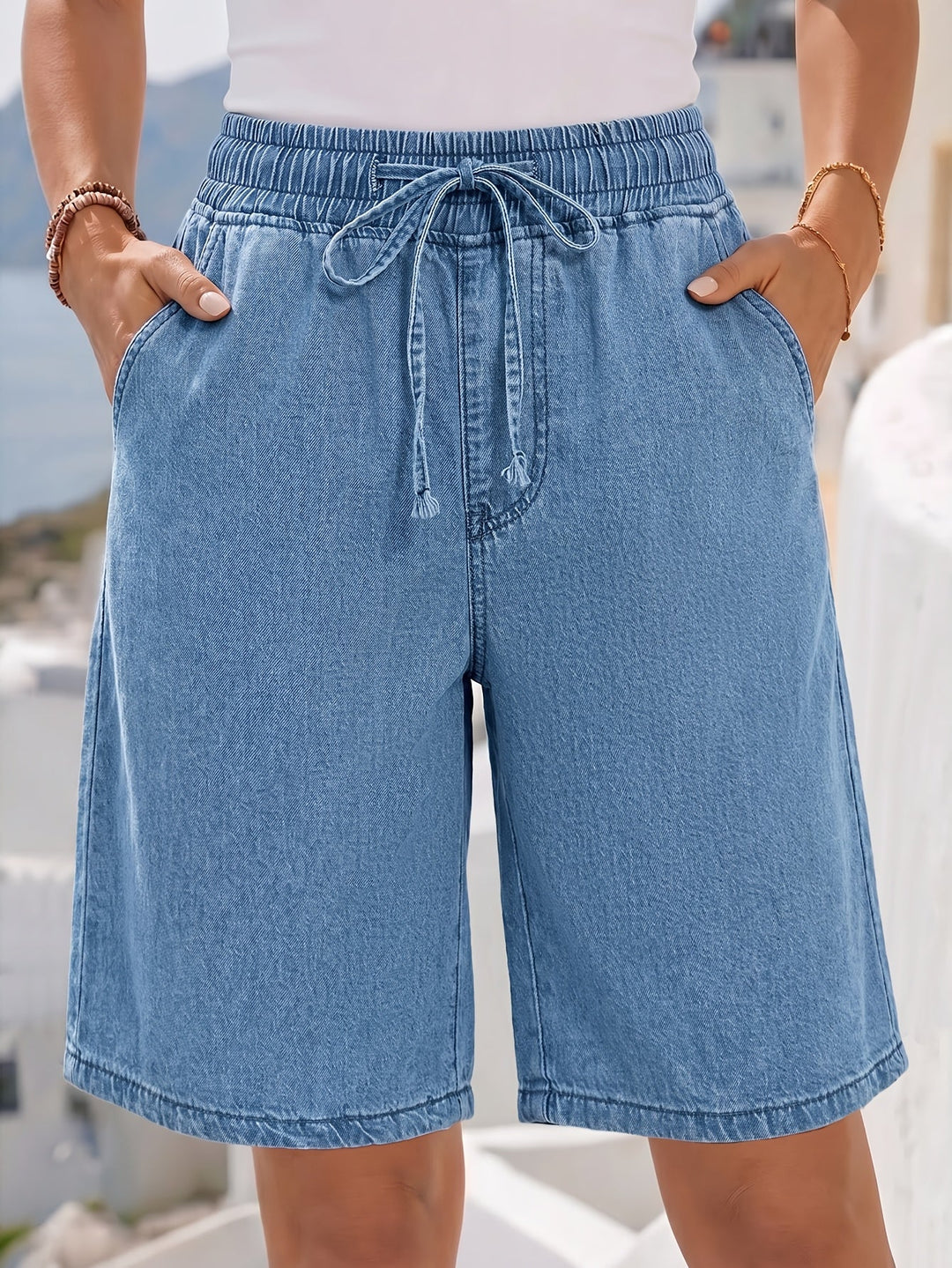 Stylish women's light blue wide-leg denim Bermuda shorts, featuring a comfortable drawstring waist for summer.