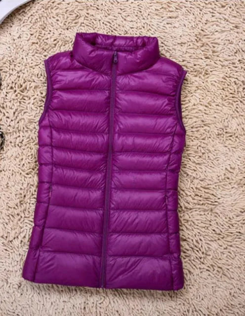 Three-quarter view of a red women's lightweight puffer vest, quilted design and a cozy high collar