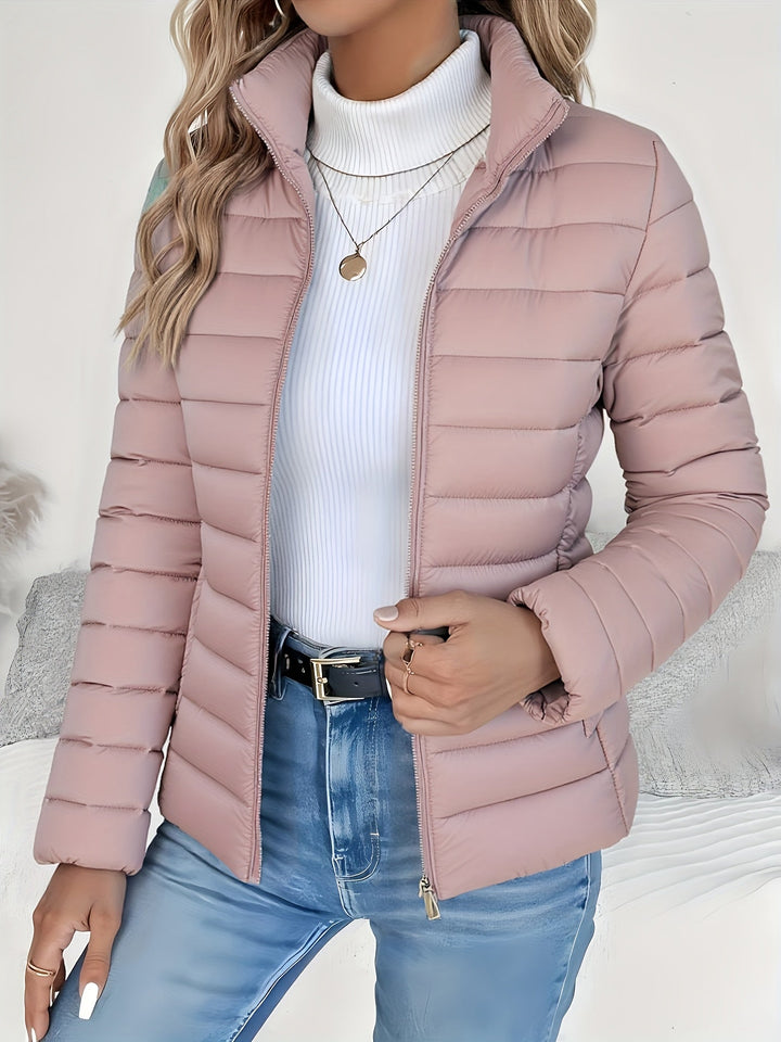 Stylish ladies' quilted puffer jacket with a stand collar. Zip-up, lightweight and perfect for fall/winter.