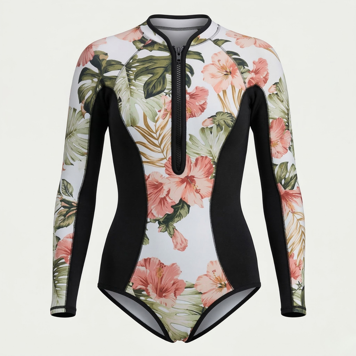Woman wearing a long sleeve tropical print surf suit for active water sports & sun protection on the beach.