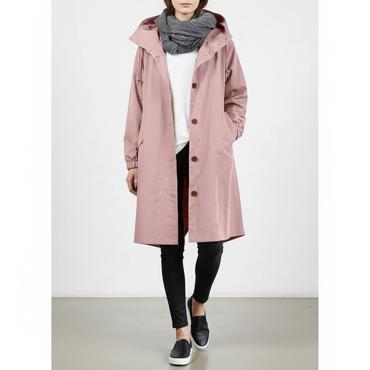 Stylish women's water resistant longline rain jacket with hood, perfect for travel & outdoor wear.