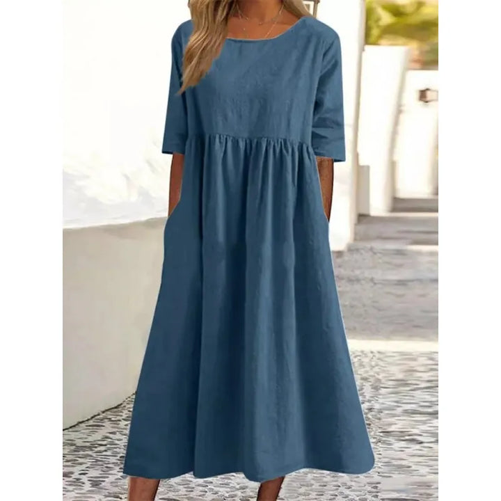 Modest women's long maxi dress with half-sleeves, round neck, & practical pockets.