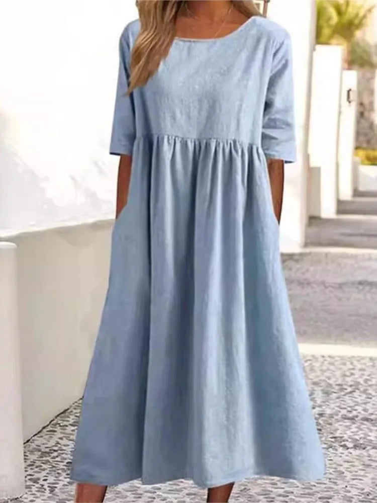 Elegant women's midi dress featuring a round neck & short sleeves. Flowy fabric for a comfortable summer look.