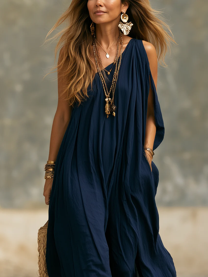 Chic navy one-shoulder wide leg jumpsuit, flowing draped design, perfect for vacation or resort outings.