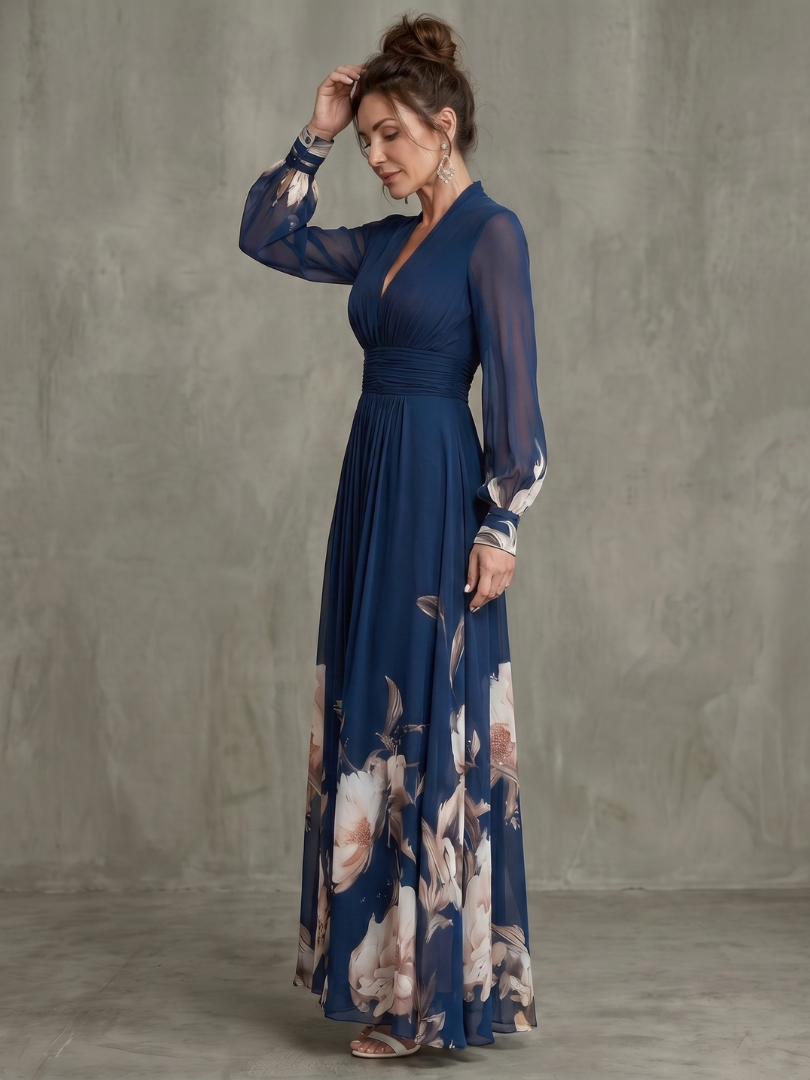 Women's navy flowy pleated maxi dress, showing its elegant silhouette and sheer long sleeves from a side angle.