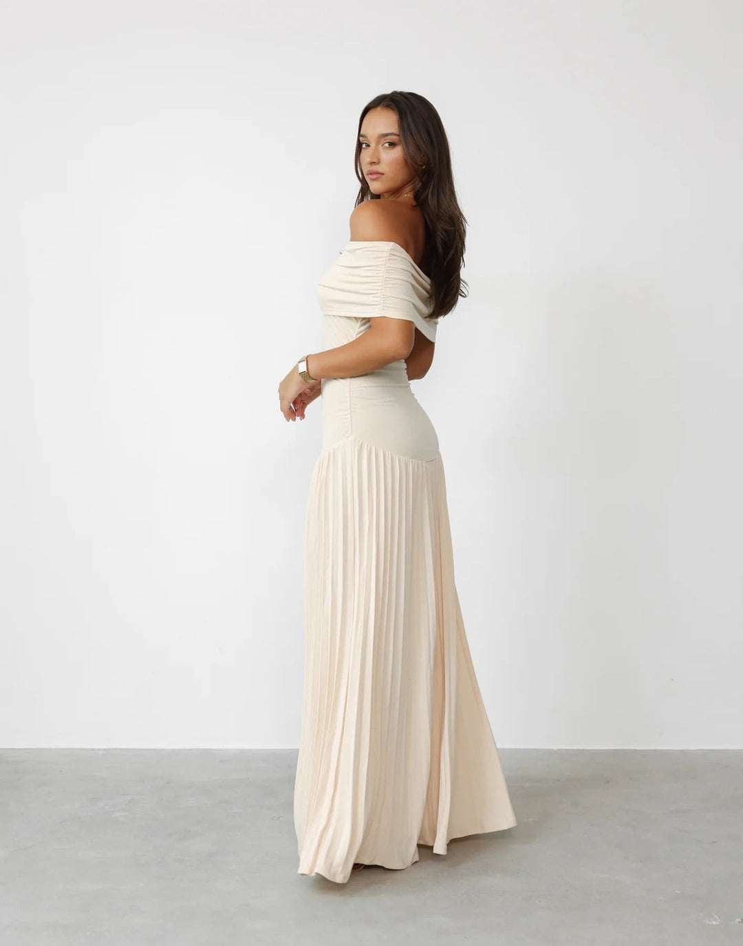 Cream off-shoulder pleated maxi evening gown, a chic choice for formal wear.