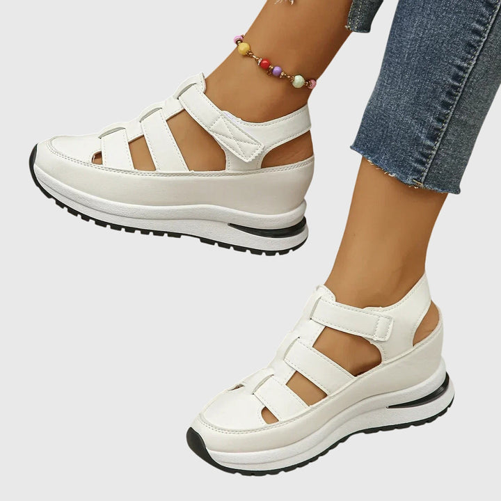Woman's foot in beige orthopedic sandals, showcasing adjustable arch support for casual summer wear.