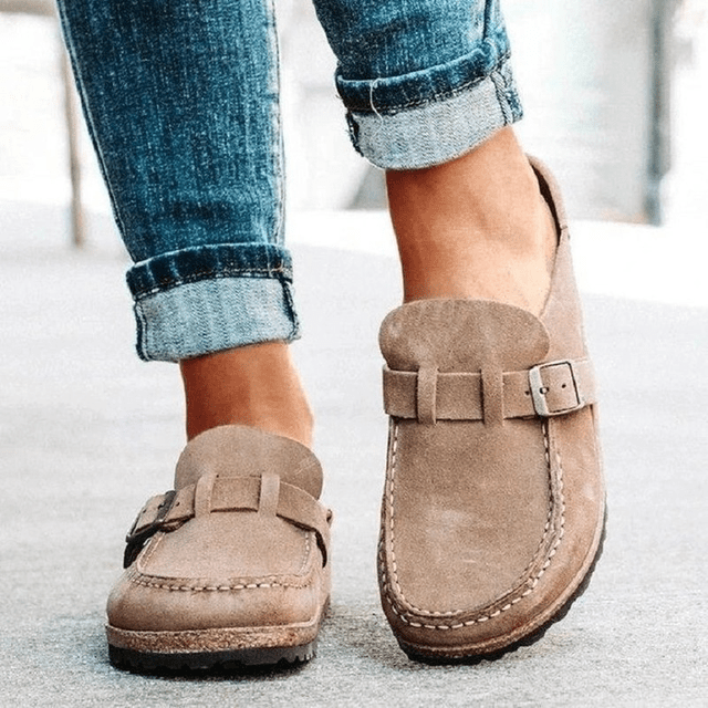 Women's feet in orthopedic slip-on mules, showcasing all-day comfort & support for casual everyday wear.