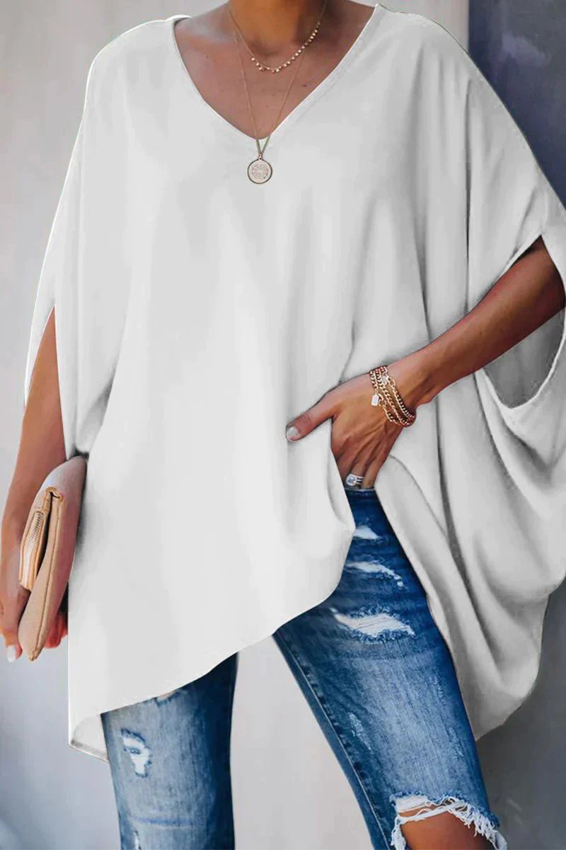 Model wears a trendy women's oversized batwing sleeve V-neck tunic top for a relaxed and fashionable look.