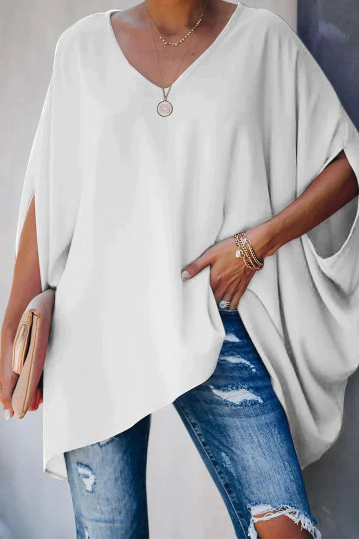 Model wears a trendy women's oversized batwing sleeve V-neck tunic top for a relaxed and fashionable look.