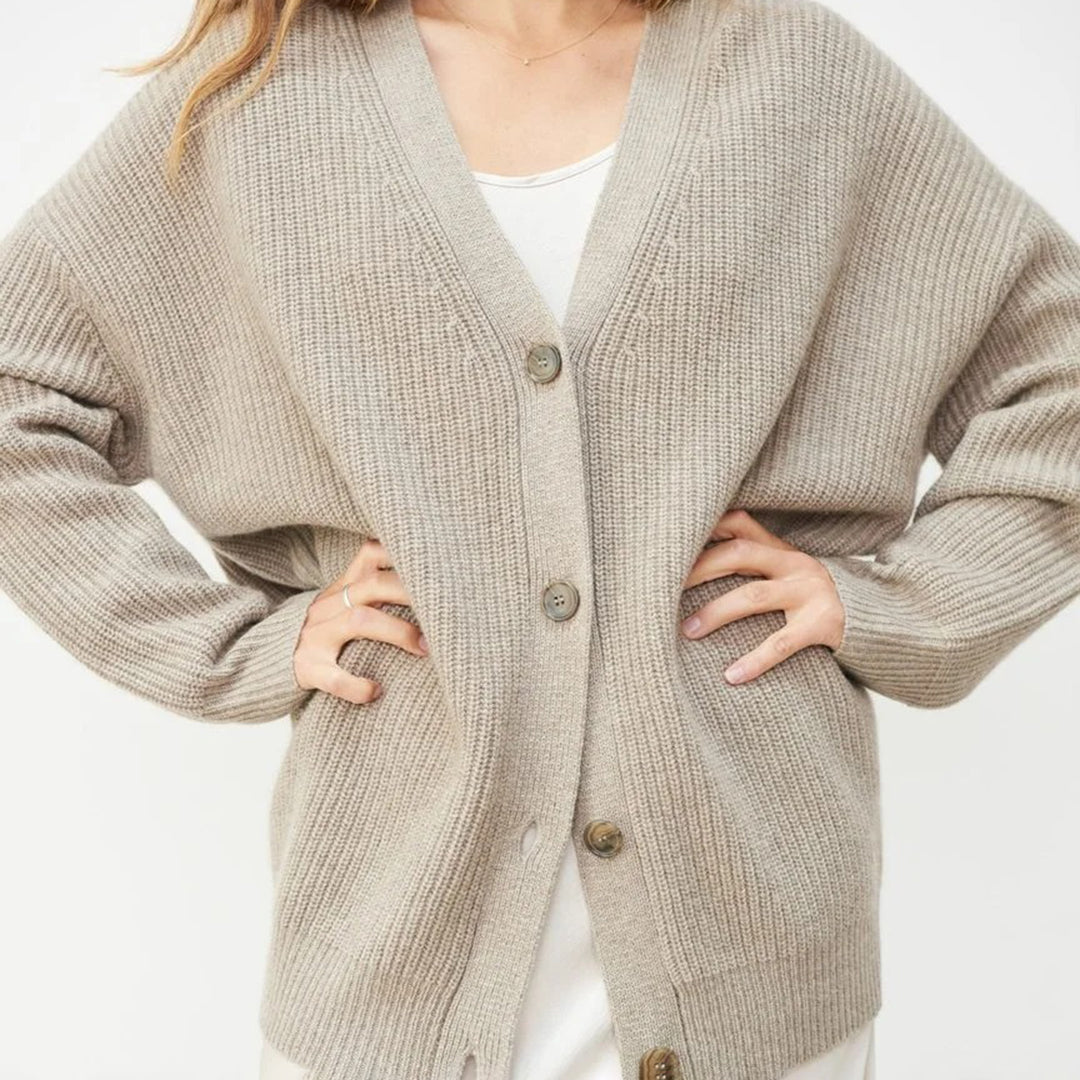 Women's oversized button-up cardigan, showcasing its relaxed fit & soft knit texture.