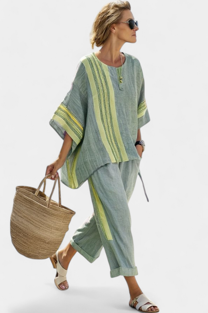 Stylish women's summer fashion set: oversized embroidered top and matching striped trousers.