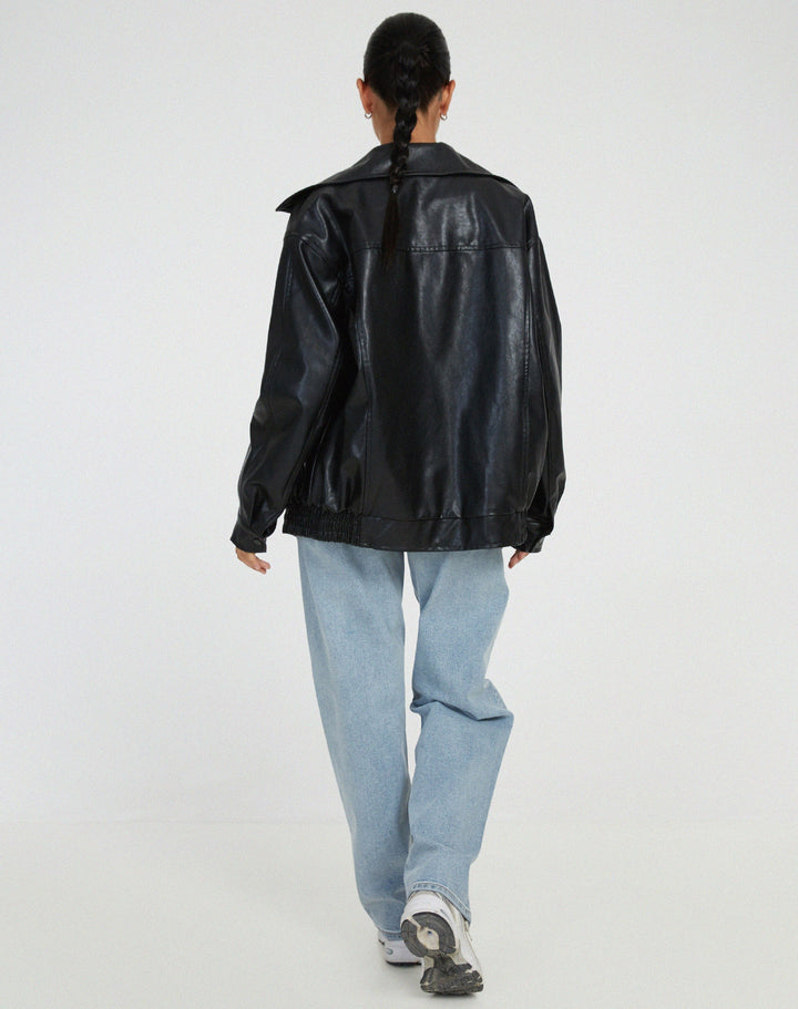 Back view of a women's brown oversized faux leather bomber jacket, emphasizing its relaxed and chic silhouette.