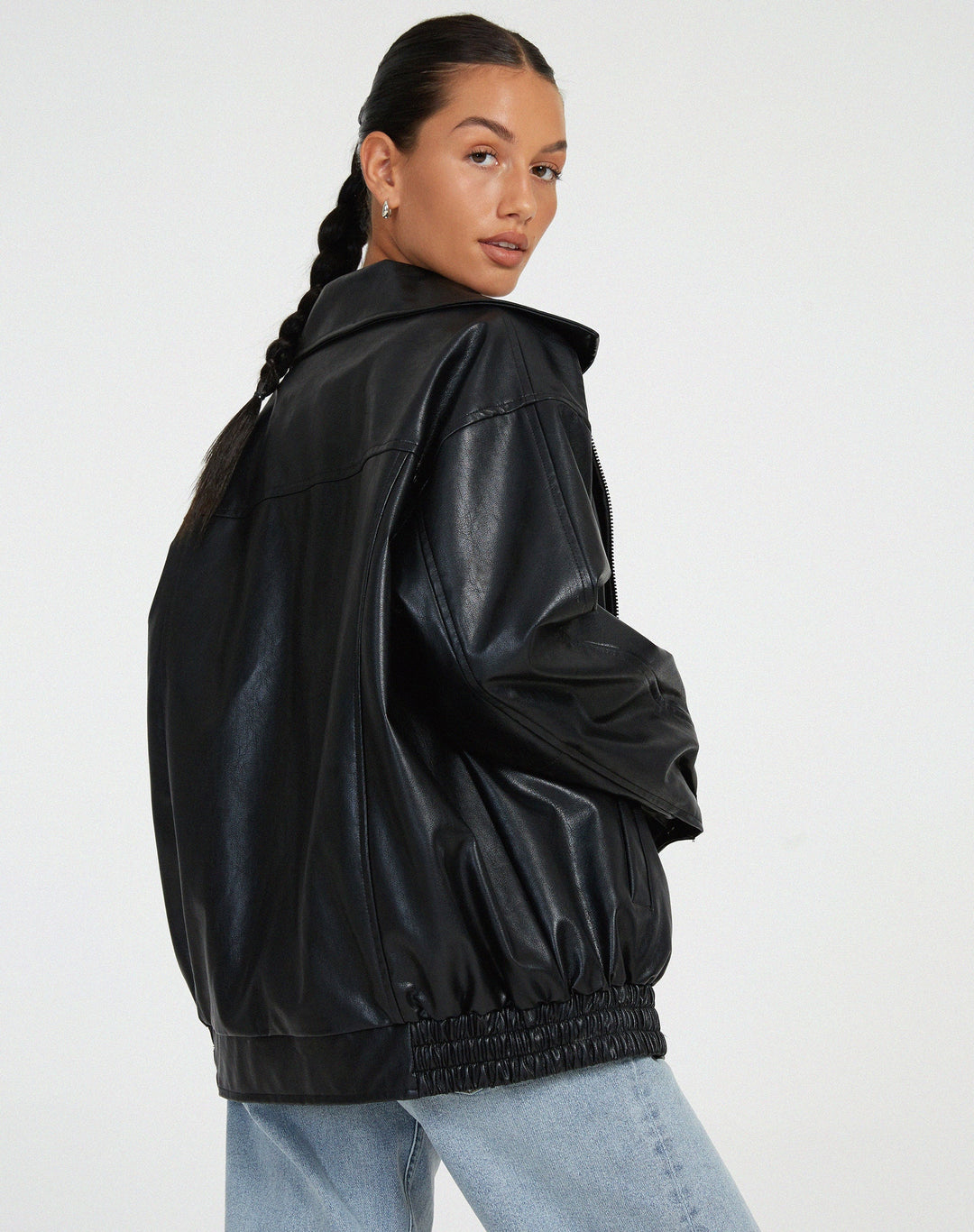 Women's oversized black faux leather bomber jacket, a fashionable and versatile piece of outerwear.