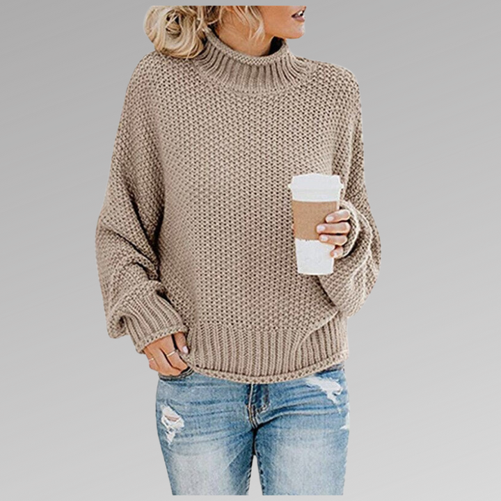 Stylish women's oversized chunky knit sweater, featuring a snug turtleneck for warm winter fashion.