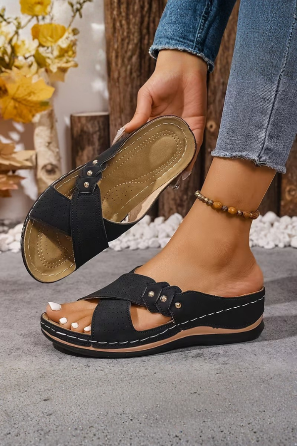 Stylish women's perforated wedge sandals. Cushioned, lightweight casual footwear, perfect for summer fashion.