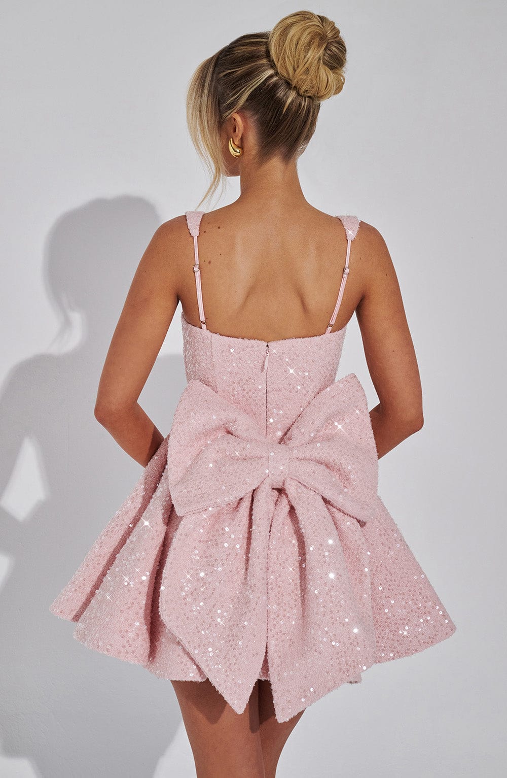 Shimmering pink sequin skater homecoming dress for women, adorned with a stylish bow.