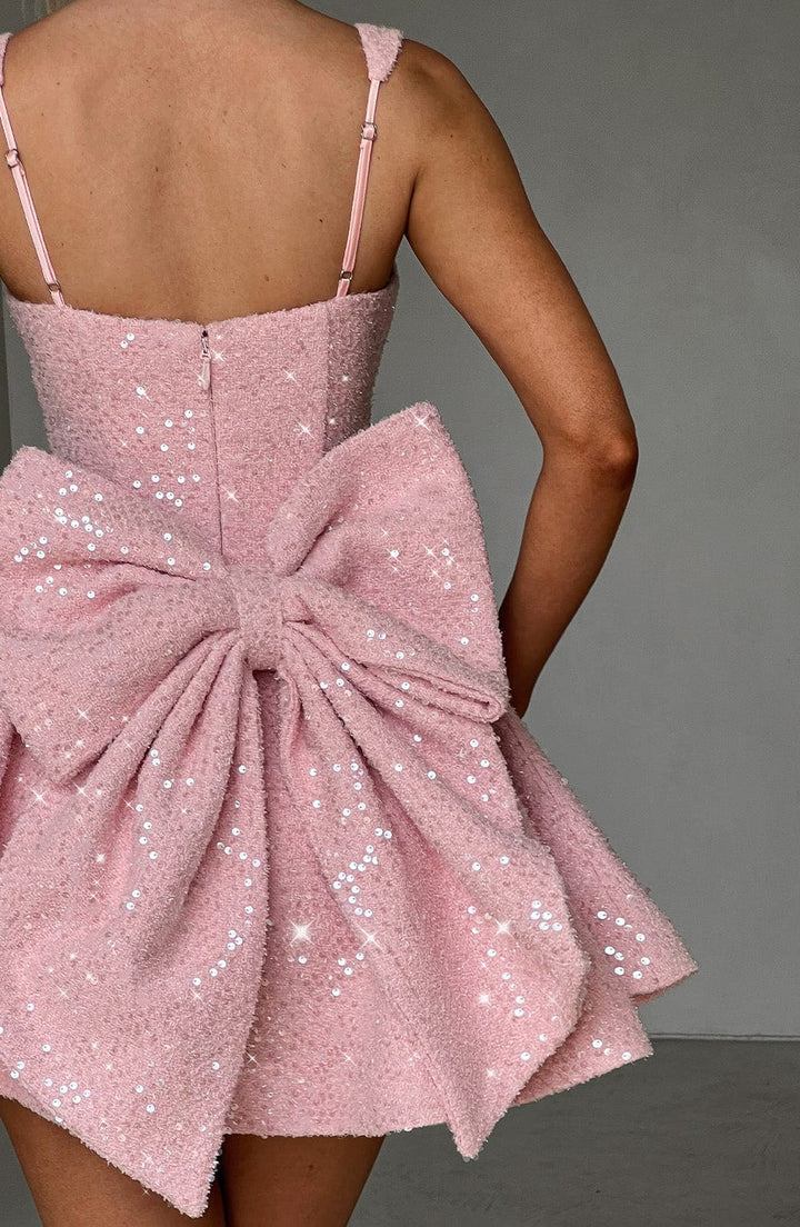 Sparkling pink sequin skater dress with a bow, an ideal women's party or homecoming outfit.