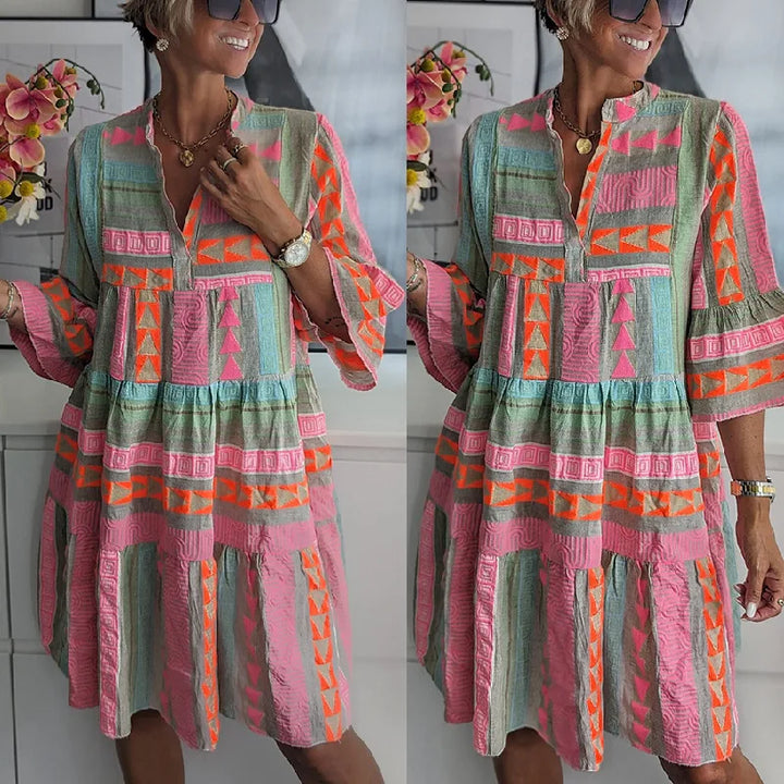 Flowy women's tiered mini spring dress with a delicate geometric print, V-neck, and 3/4 sleeves. Comfortable daywear.