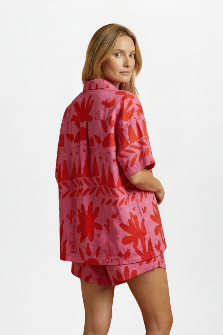 Vibrant pink tropical print women's shirt & high-waisted shorts set, a stylish summer co-ord for holidays.