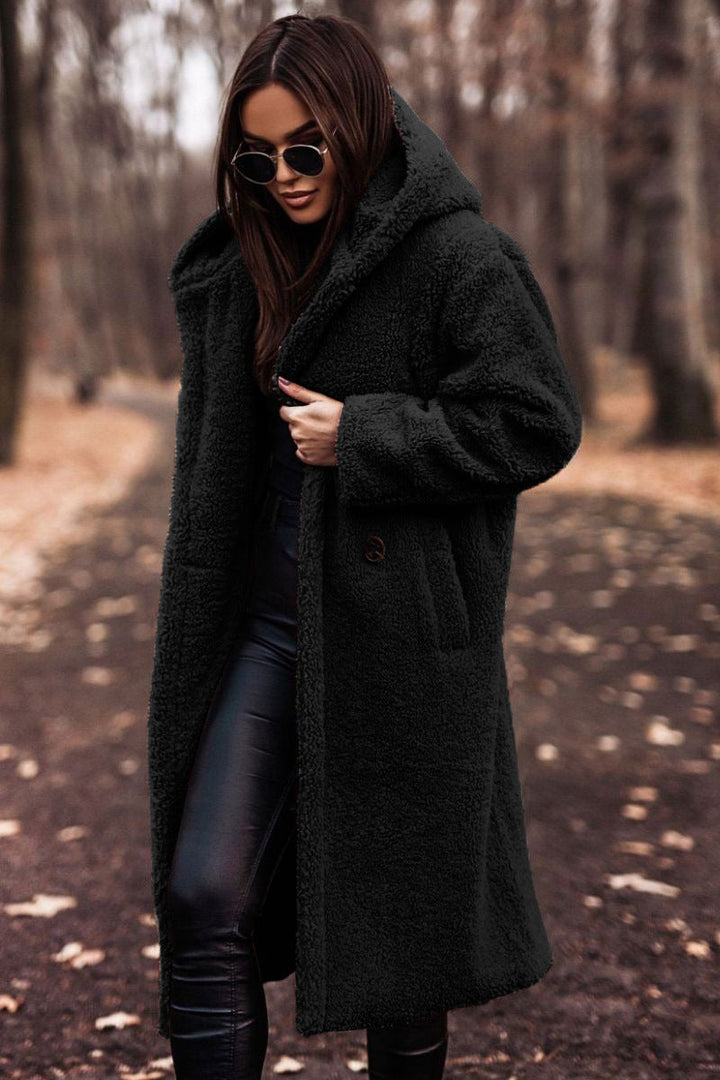 Full-length view of a women's plush faux shearling hooded winter coat