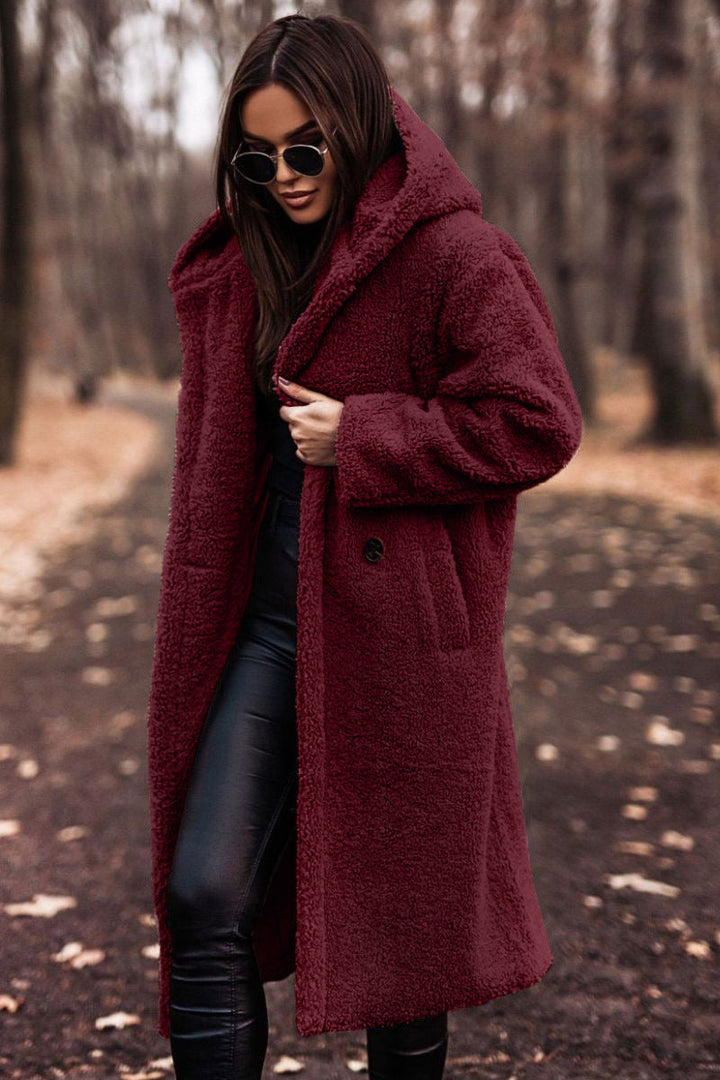 Detail of the plush faux shearling texture on a women's hooded mid-calf coat