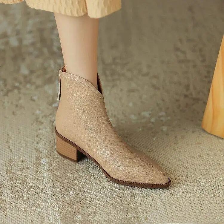 Slip-on women's ankle boots with pointed toe & low heel, elegant and versatile.