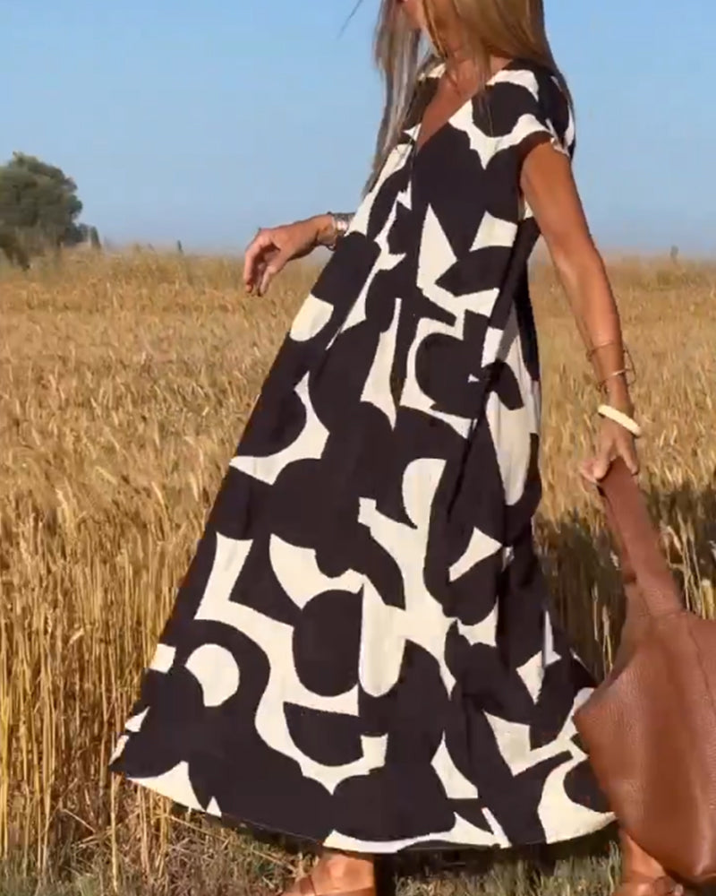 Comfortable women's abstract print summer dress with V-neck. Relaxed fit, modern design, cap sleeves.