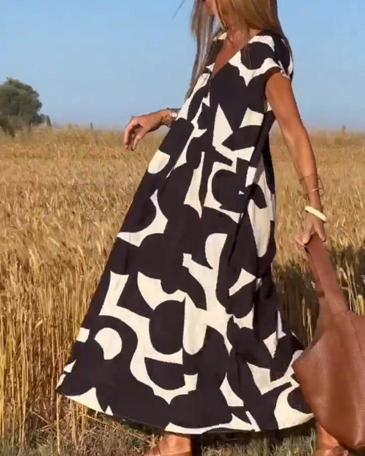 Comfortable women's abstract print summer dress with V-neck. Relaxed fit, modern design, cap sleeves.