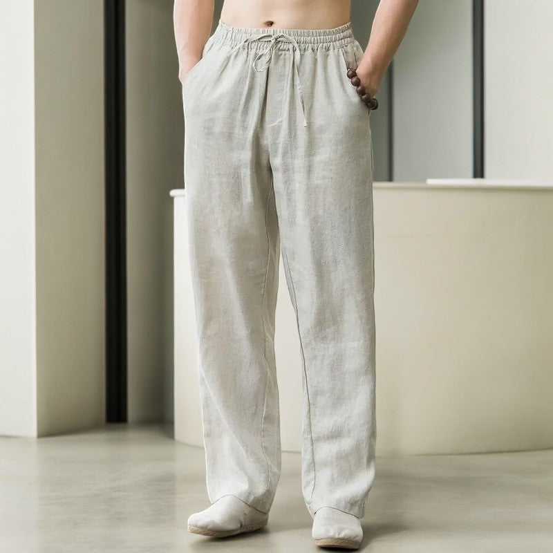 Stack of folded women's linen pants in various colors: white, grey, and navy, relaxed fit