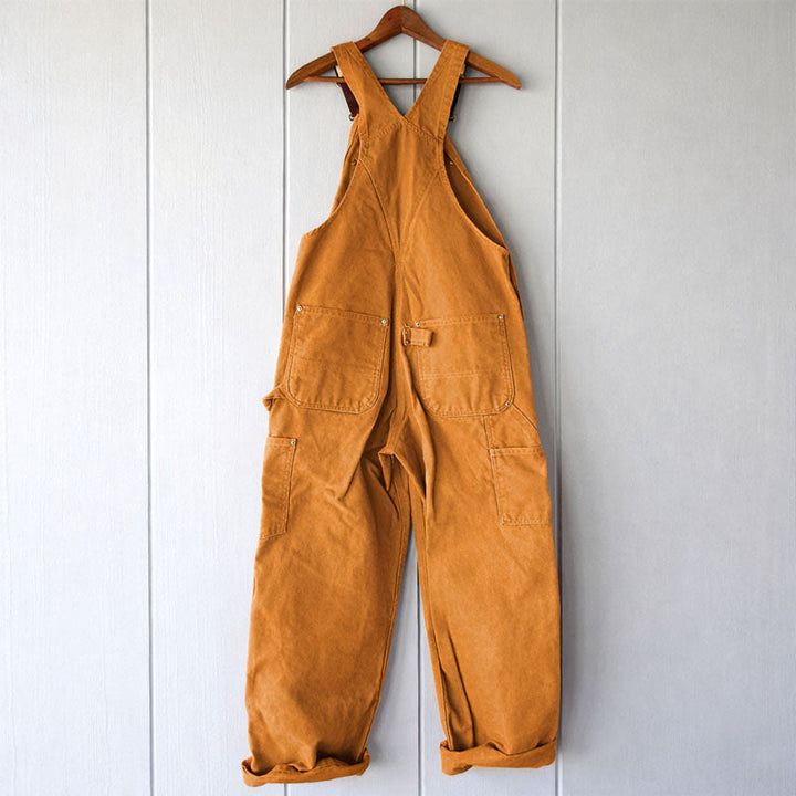 Model wearing women's relaxed fit overalls, showcasing a comfortable, sleeveless design and versatile utility pockets.