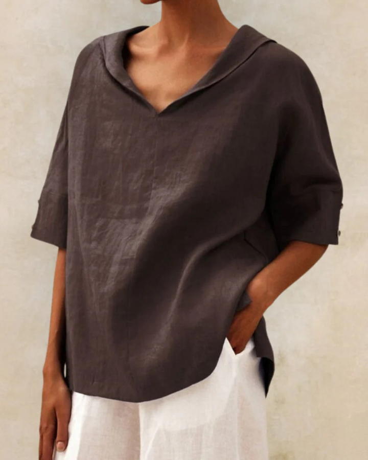 Women's relaxed V-neck short sleeve blouse laid flat, highlighting its casual style and comfortable fit for summer.