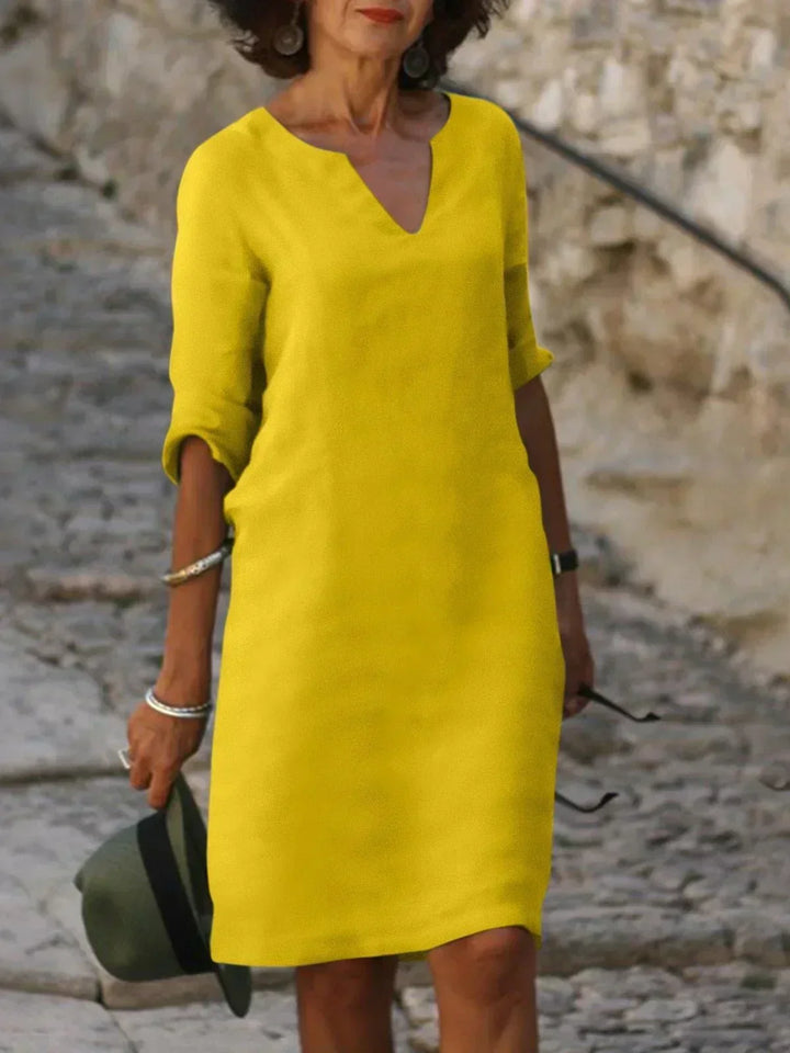 Women's relaxed V-neck midi dress with 3/4 sleeves and pockets. Comfortable, casual, and elegant for any day.