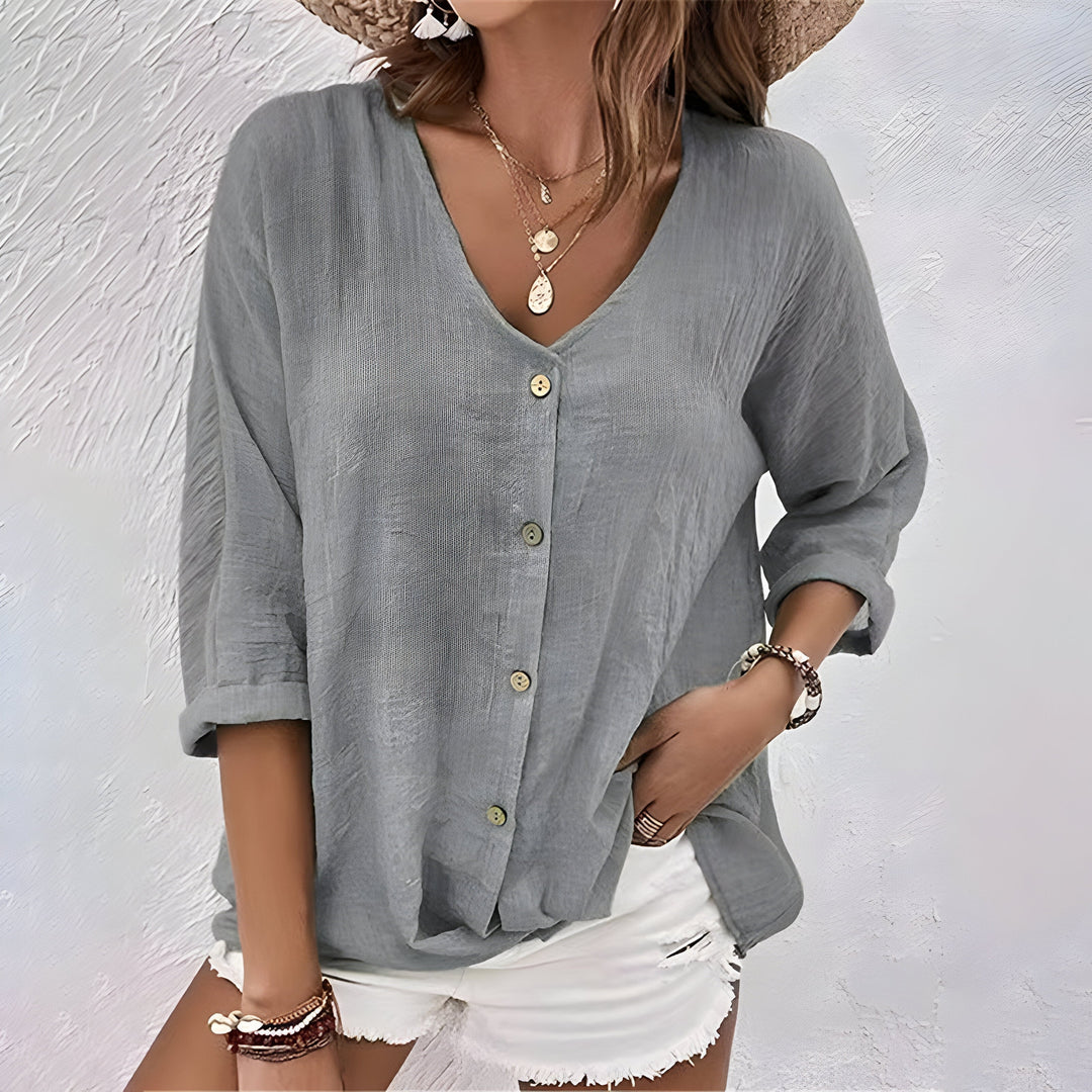 Comfortable women's relaxed fit V-neck blouse. Features roll sleeves & button front, a chic summer top.
