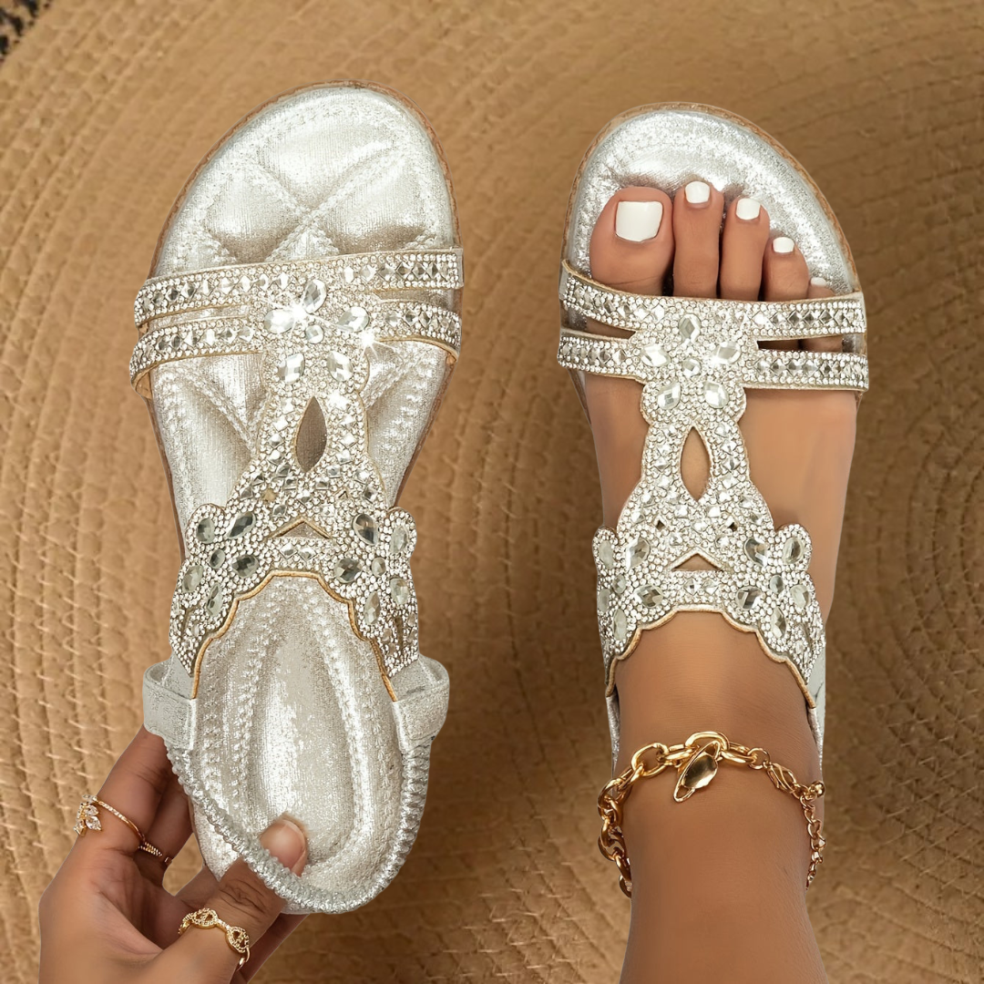 Open-toe women's flat sandals adorned with shimmering rhinestones, essential summer footwear for comfort.