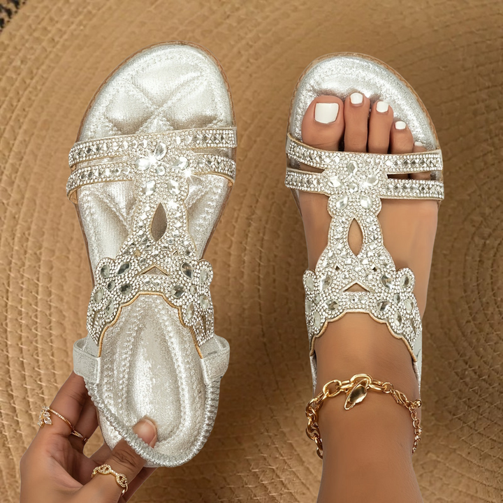 Open-toe women's flat sandals adorned with shimmering rhinestones, essential summer footwear for comfort.
