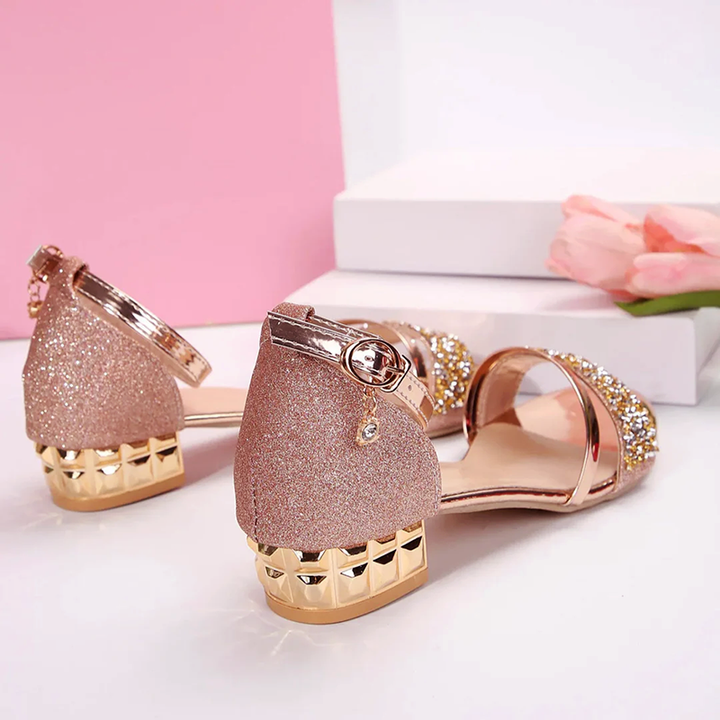 Chic women's block heel sandals featuring dazzling rhinestones & a stylish chain ankle strap for glamorous wear.
