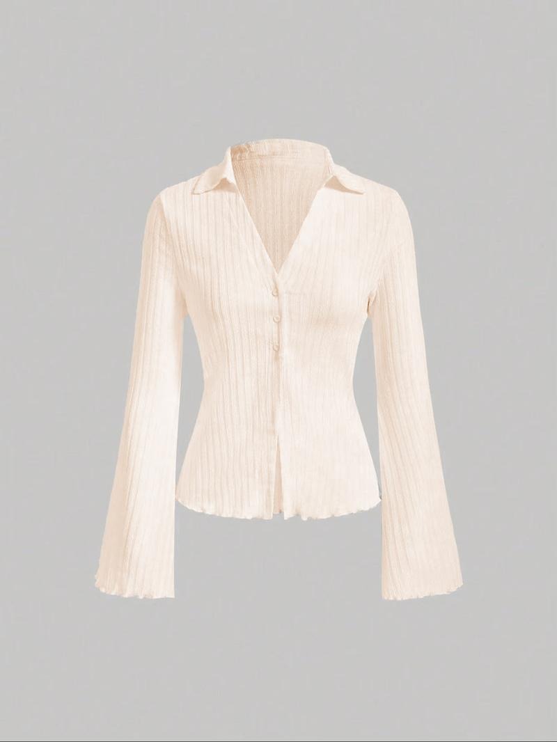Brunette model wearing a white ribbed knit flared sleeve blouse, casual chic and comfortable.