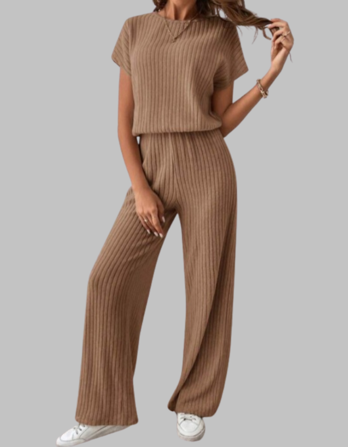 Model wears a stylish ribbed women's two-piece set: short sleeve top and comfortable wide-leg lounge pants.