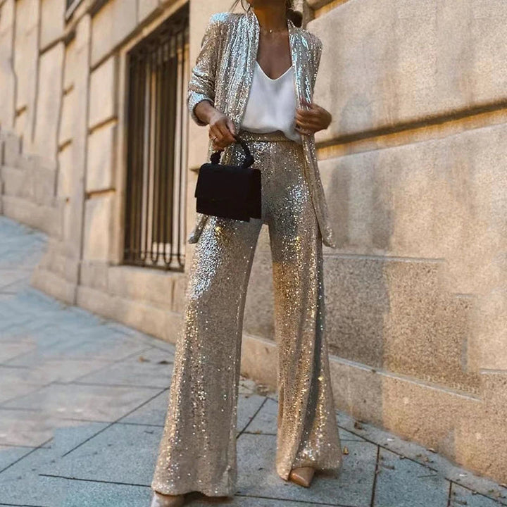 Close-up of shimmering sequins on a women's festive party top & high-waisted pants set, sparkling chic.