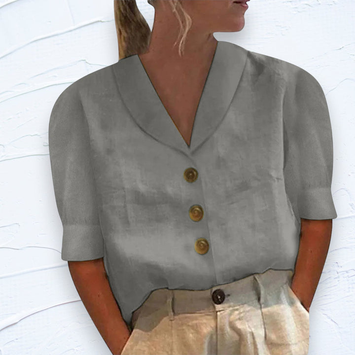 Casual women's button-front shirt with short sleeves, designed for comfort and daily wear. Versatile workwear option.