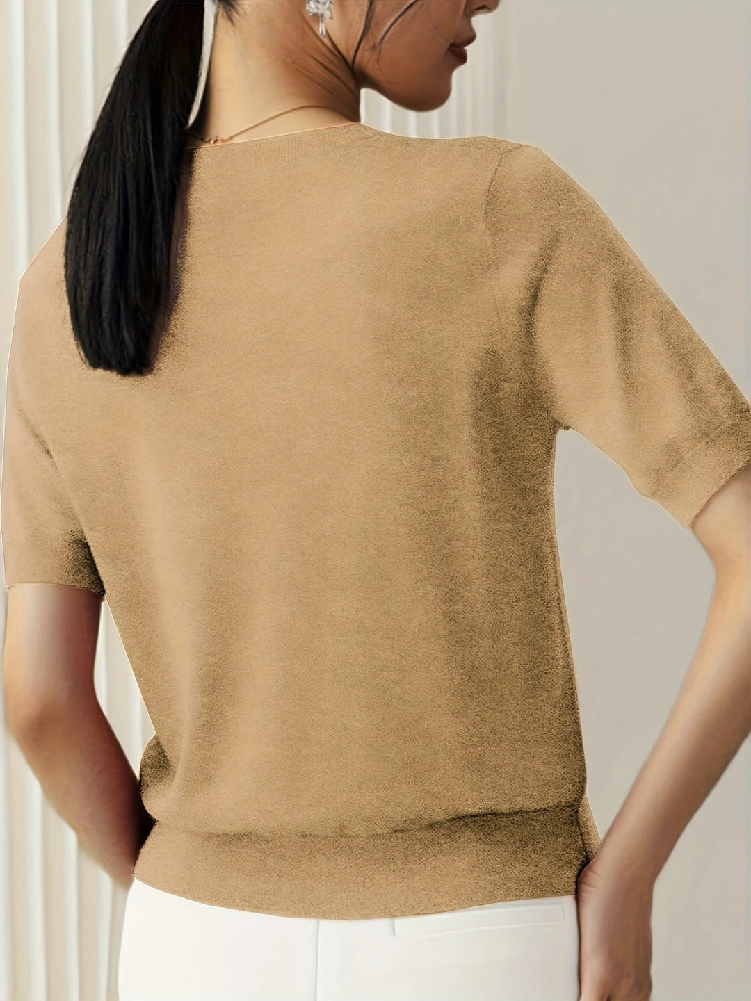 Stylish women's short sleeve top featuring a crew neck and ribbed hem.