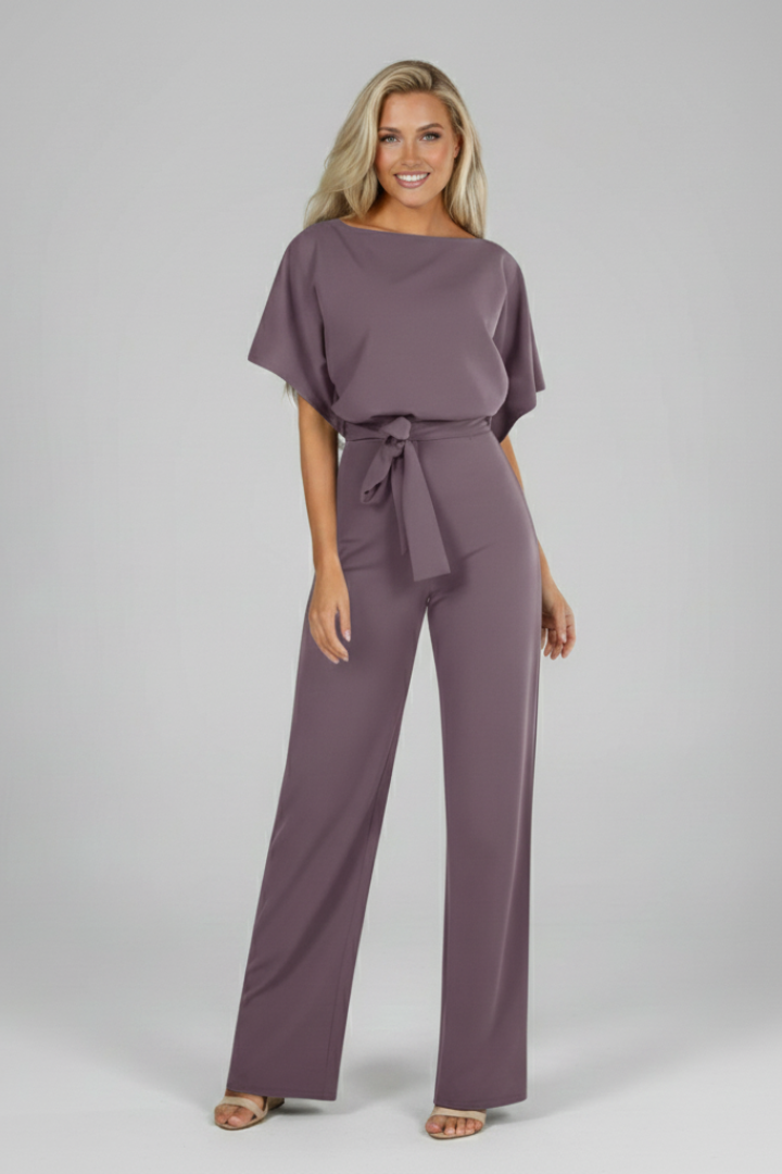 Model wearing a grey short sleeve women's jumpsuit with waist tie, styled for a chic, casual look.