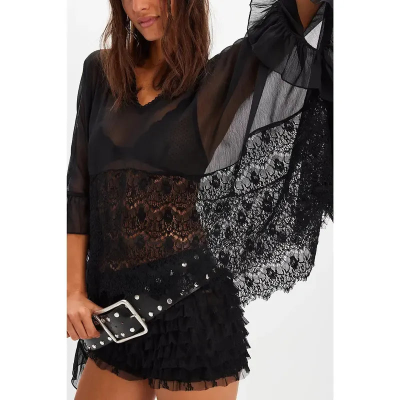 Folded Women's Siena sheer lace poncho top, highlighting intricate lace detail and sheerness.