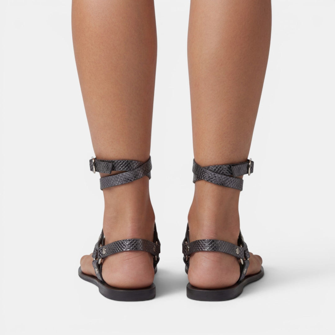Comfortable women's snake print flat sandals with stylish buckle accents for casual summer fashion.