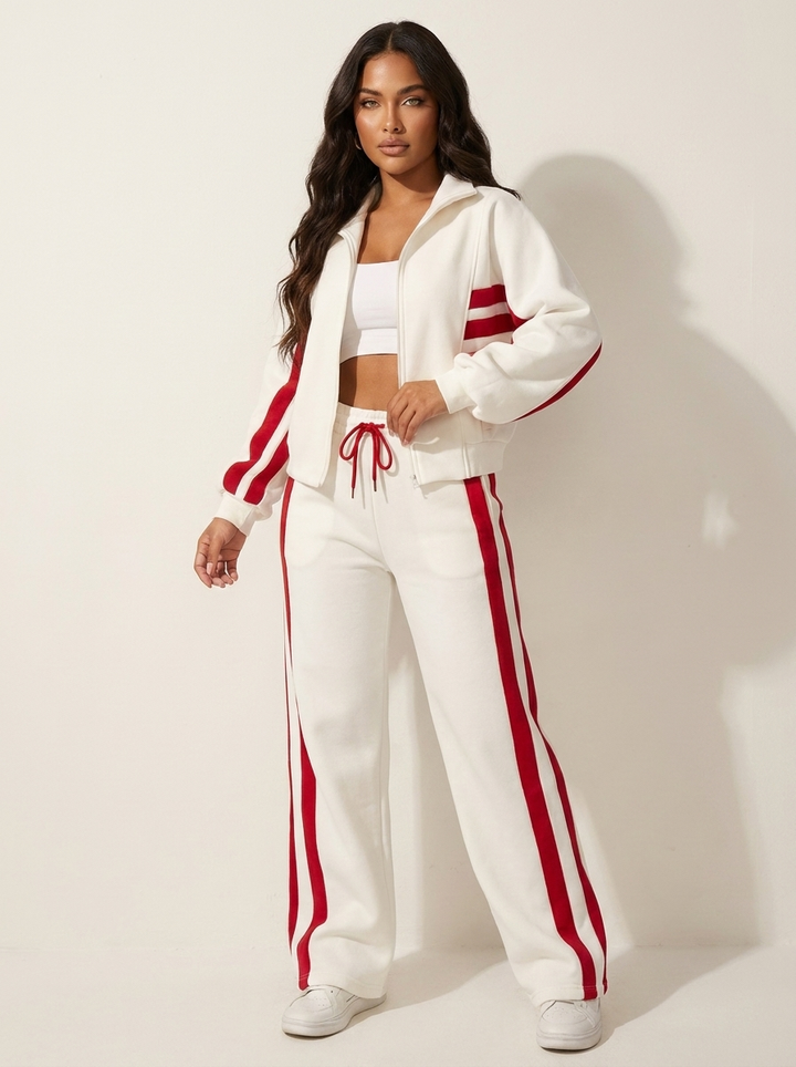 Athleisure women's two-piece tracksuit. Features zip-up jacket & wide-leg pants with stylish contrast stripes.