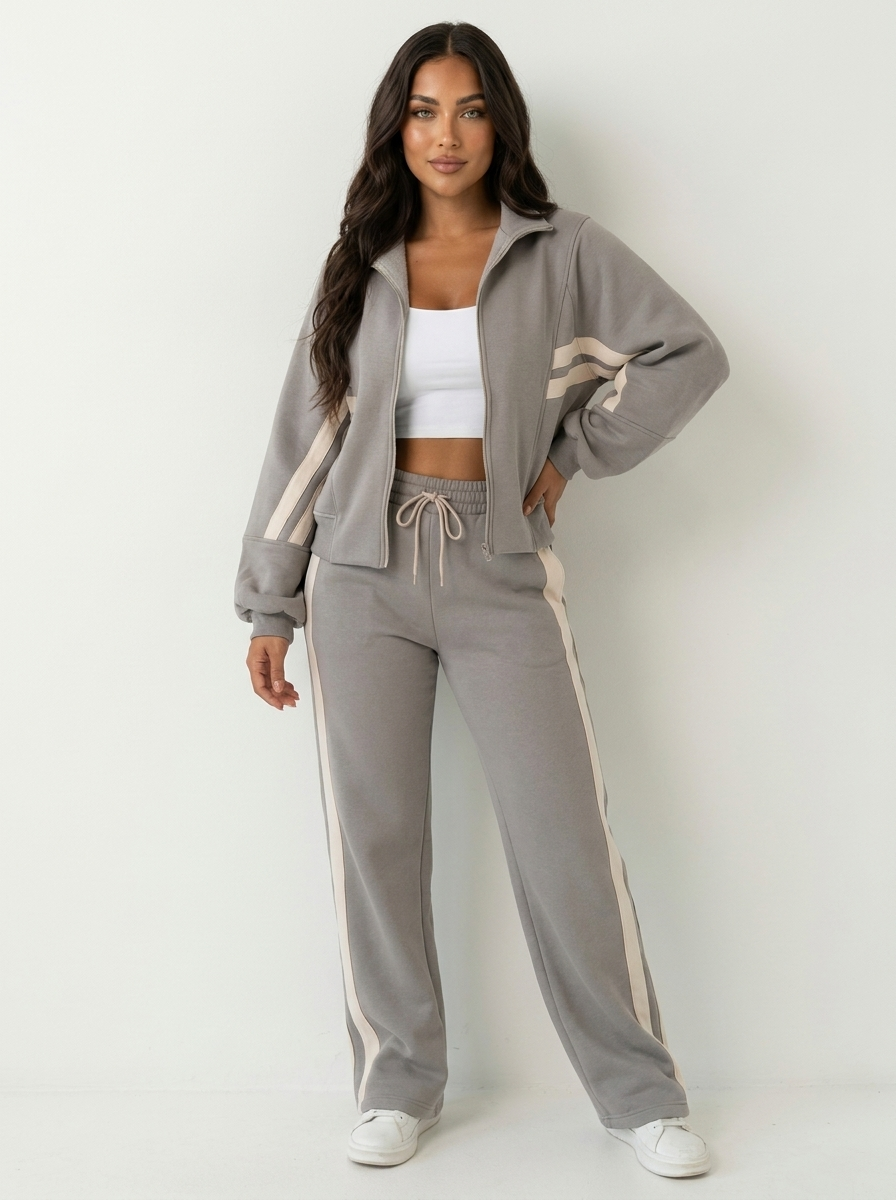 Matching women's tracksuit set. Zip-up top & wide-leg pants with modern contrast stripe detail for casual style.