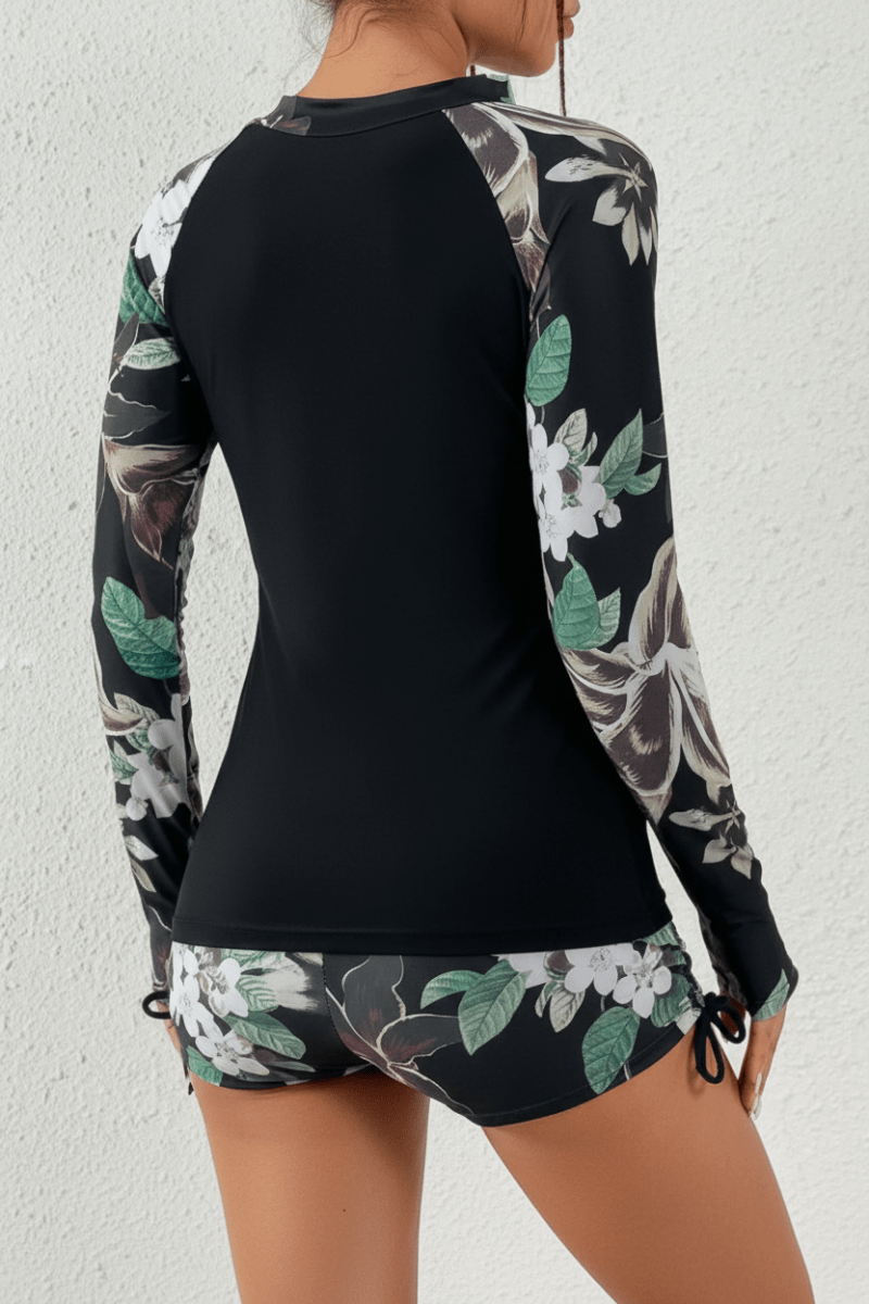 Comfortable women's two-piece rashguard swimsuit featuring a lively tropical print & high-waisted bottom.